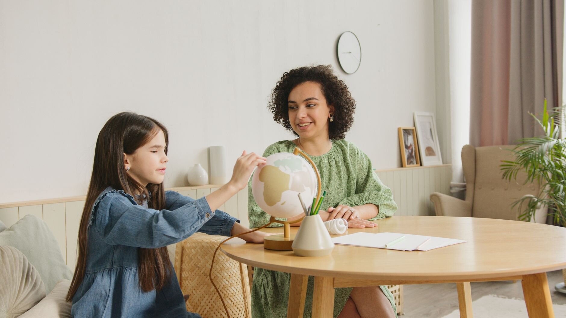 A mother and daughter exploring a globe together.